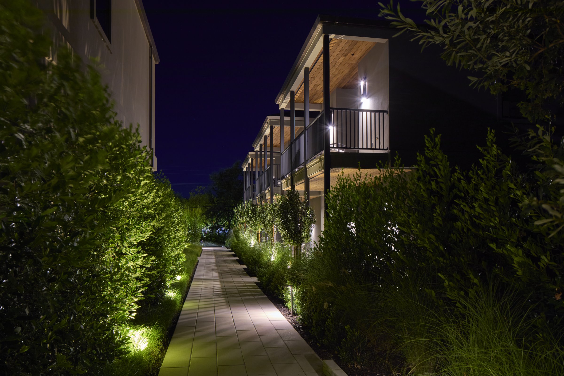 The Grove Suites building and stone path at night.